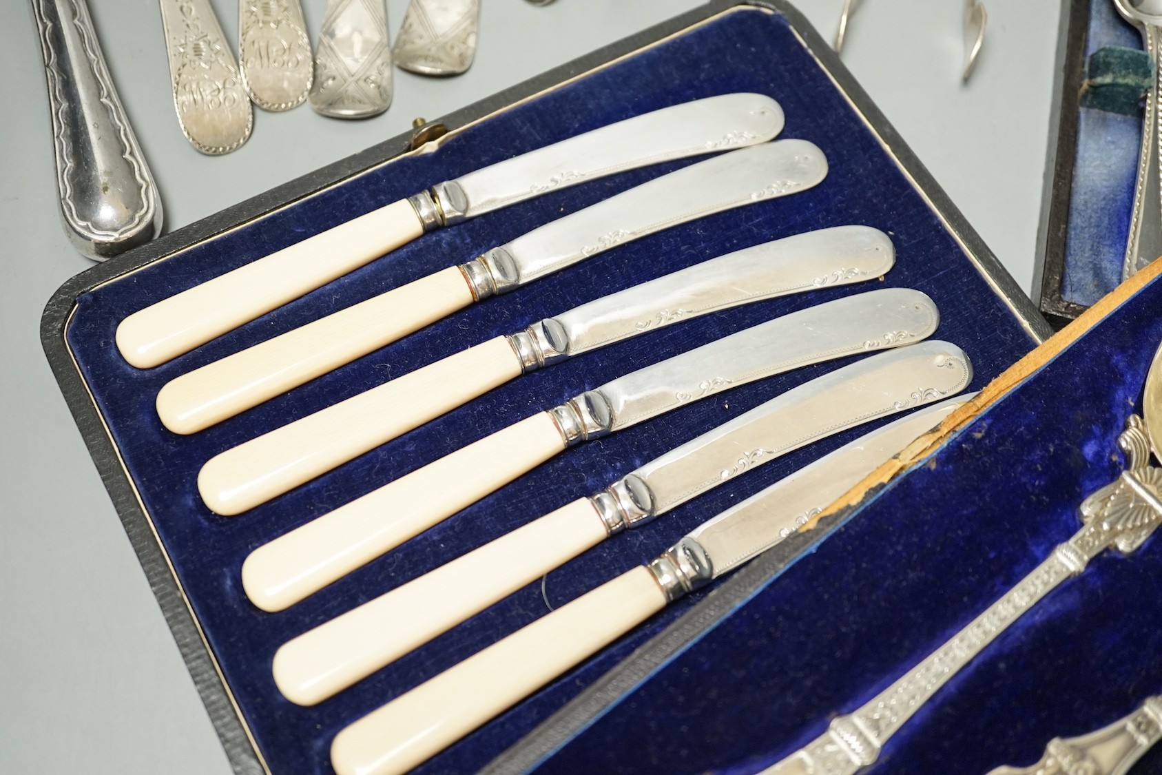 Two pairs of 18th century silver tablespoons including 'berry', a George III silver sifter spoon, pair of sugar tongs and other items including cased plated sets.